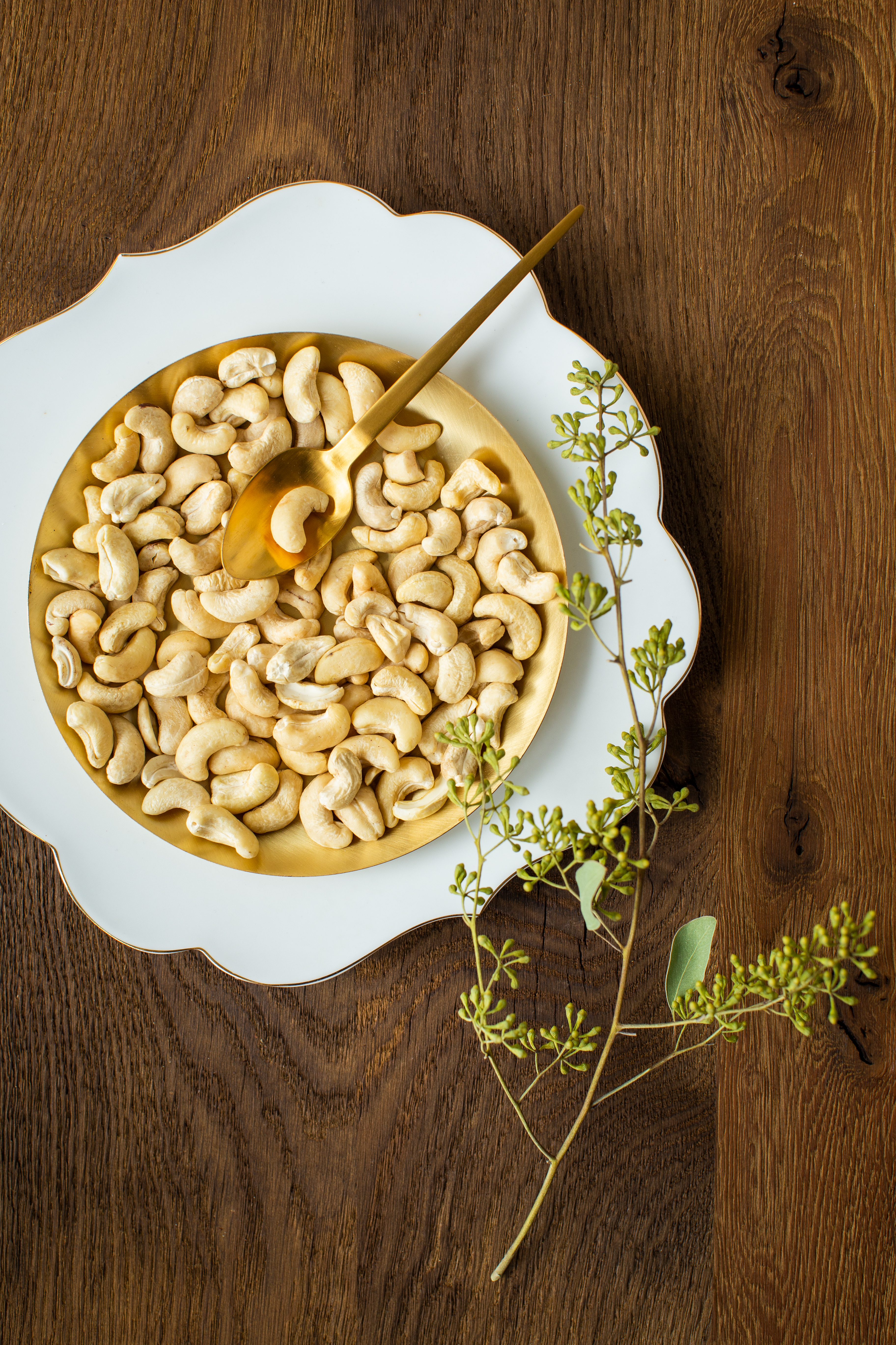 Bio Cashewkerne auf einem goldenen Teller und einem Holzuntergrund