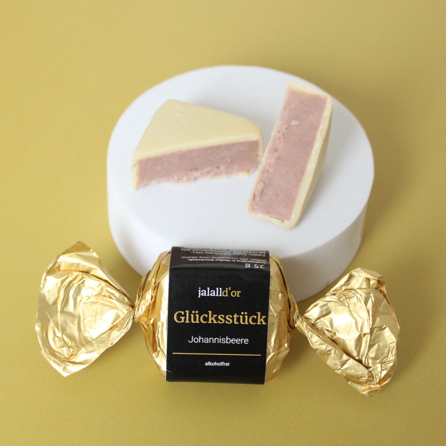 Gluecksstueck Johannisbeeren verpackt und dahinter liegt eins aufgeschnitten