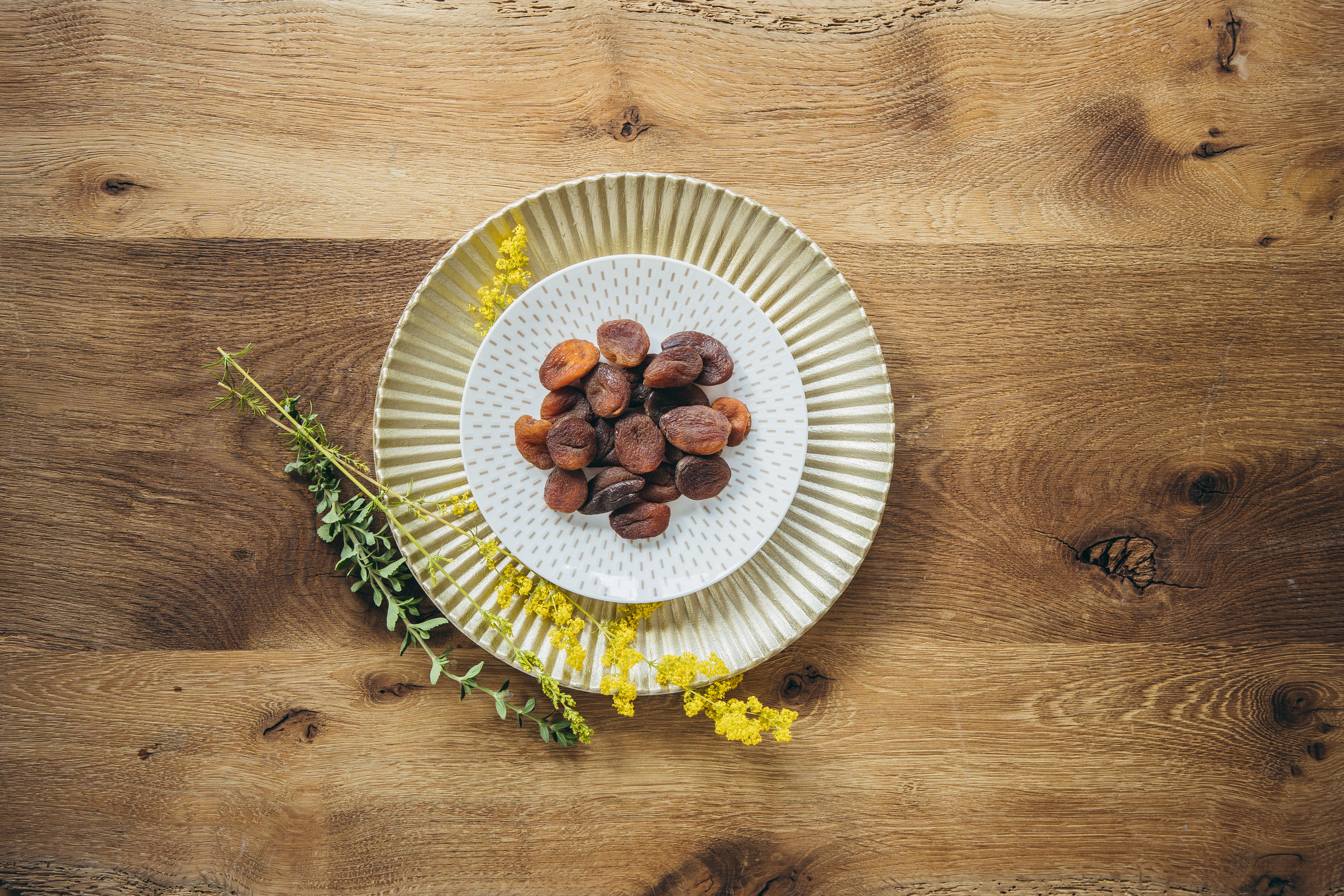 getrocknete Bio Aprikosen auf Tellern auf Holzboden