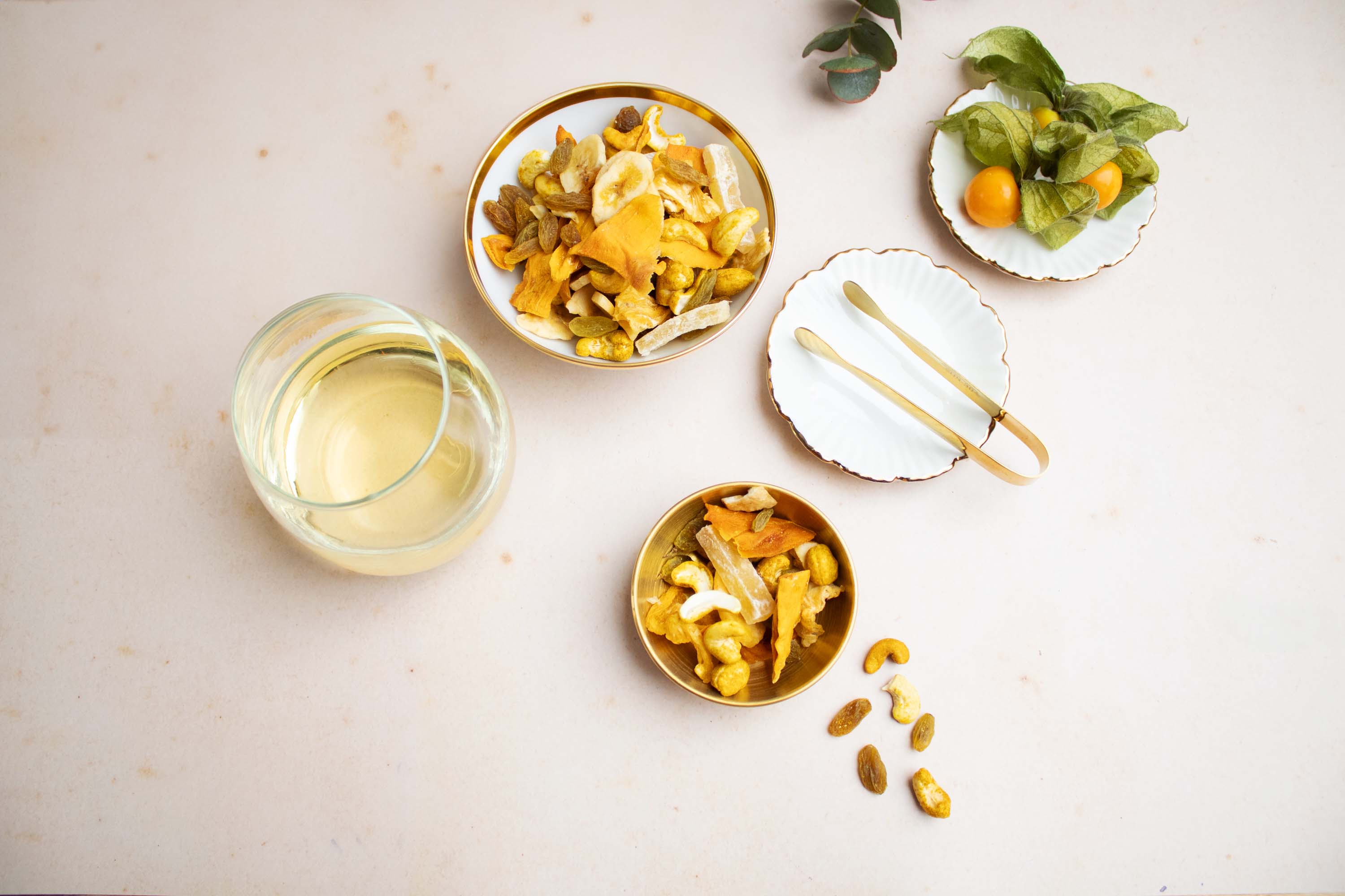 Zwei Schalen mit der Nuss-Trockenfrucht-Mischung Im (W)Einklang No. 4 im Foodparing mit einem Weißwein auf einem hellen Tisch