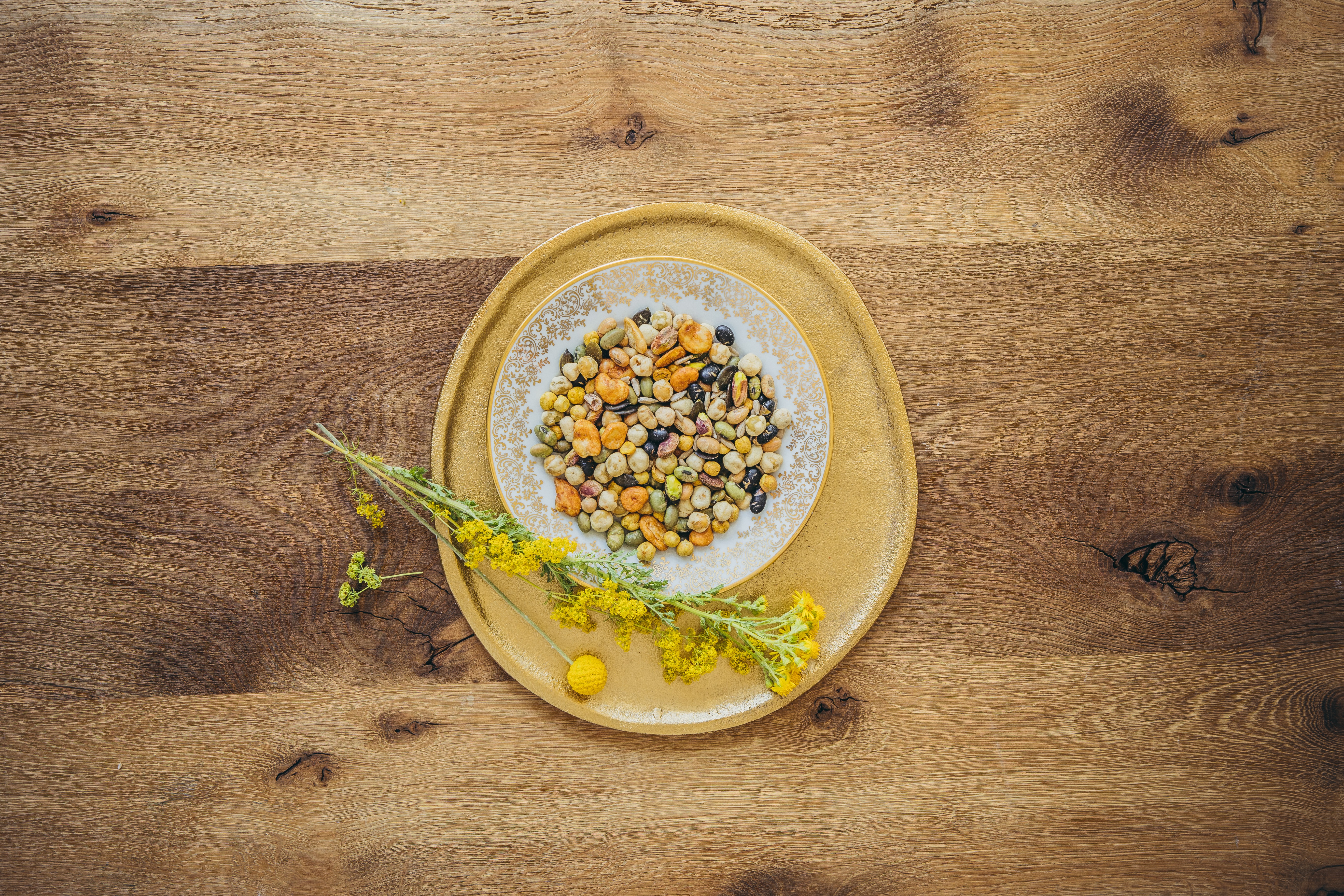 Die Mischung "Salatkernemix" liegt auf Tellern die auf einem Holzboden liegen