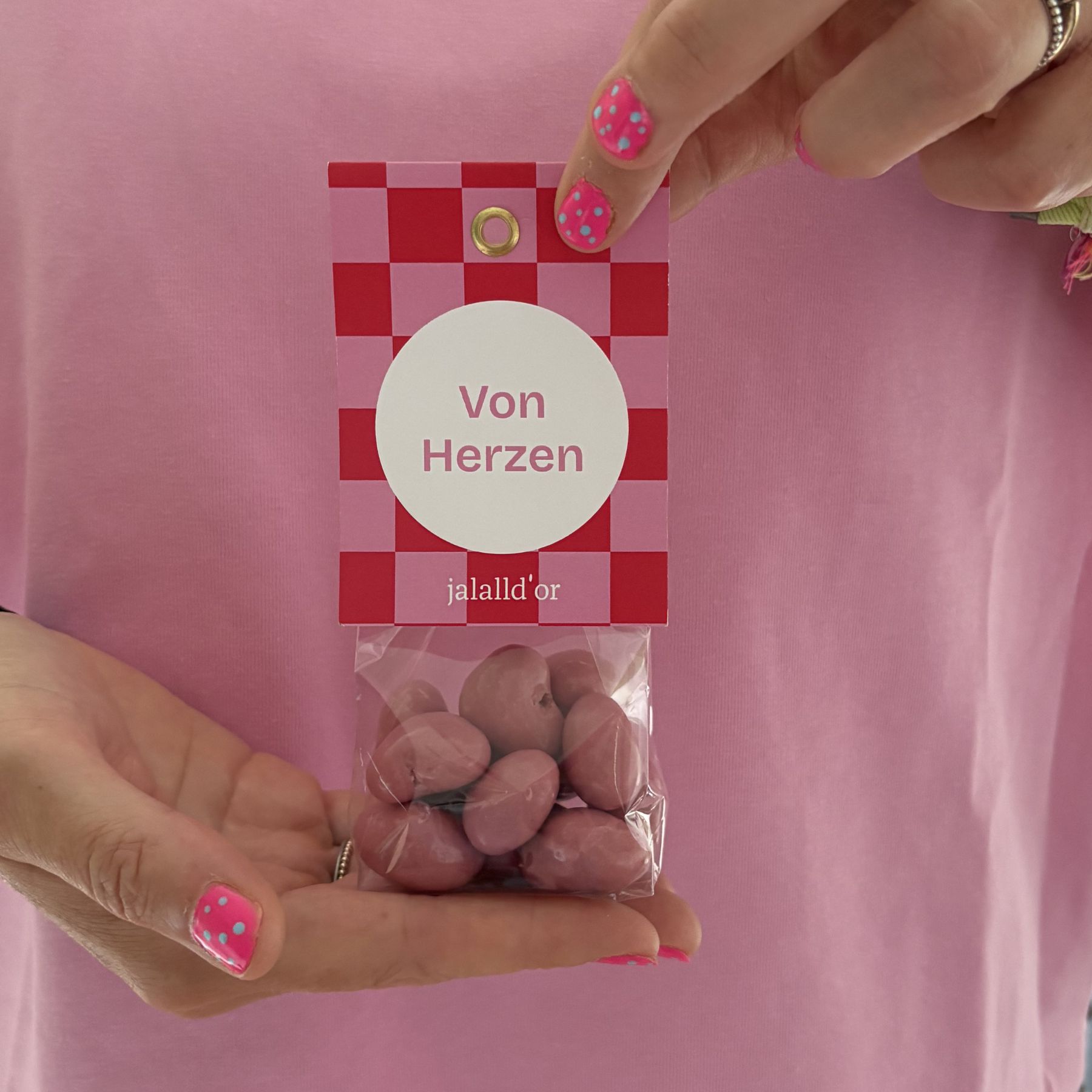 Geschenkpackung-mit-rosa-Schokoherzen-gehalten-von-2-Händen